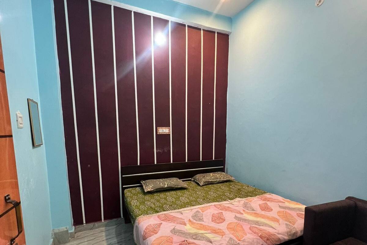 A bedroom with a bed, a ceiling fan, a wardrobe, and a chair.