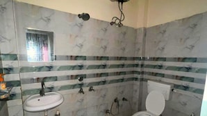 Ein Badezimmer mit Waschbecken, Toilette, Dusche und einem kleinen Fenster.