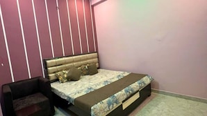 Ein Schlafzimmer mit einem Bett, einem Nachttisch und einem Sessel.