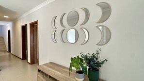 A hallway with a wooden bench, potted plants, and a series of wall-mounted mirrors. - Águia | Private Pool | 10 Pax | Albufeira (Albufeira)