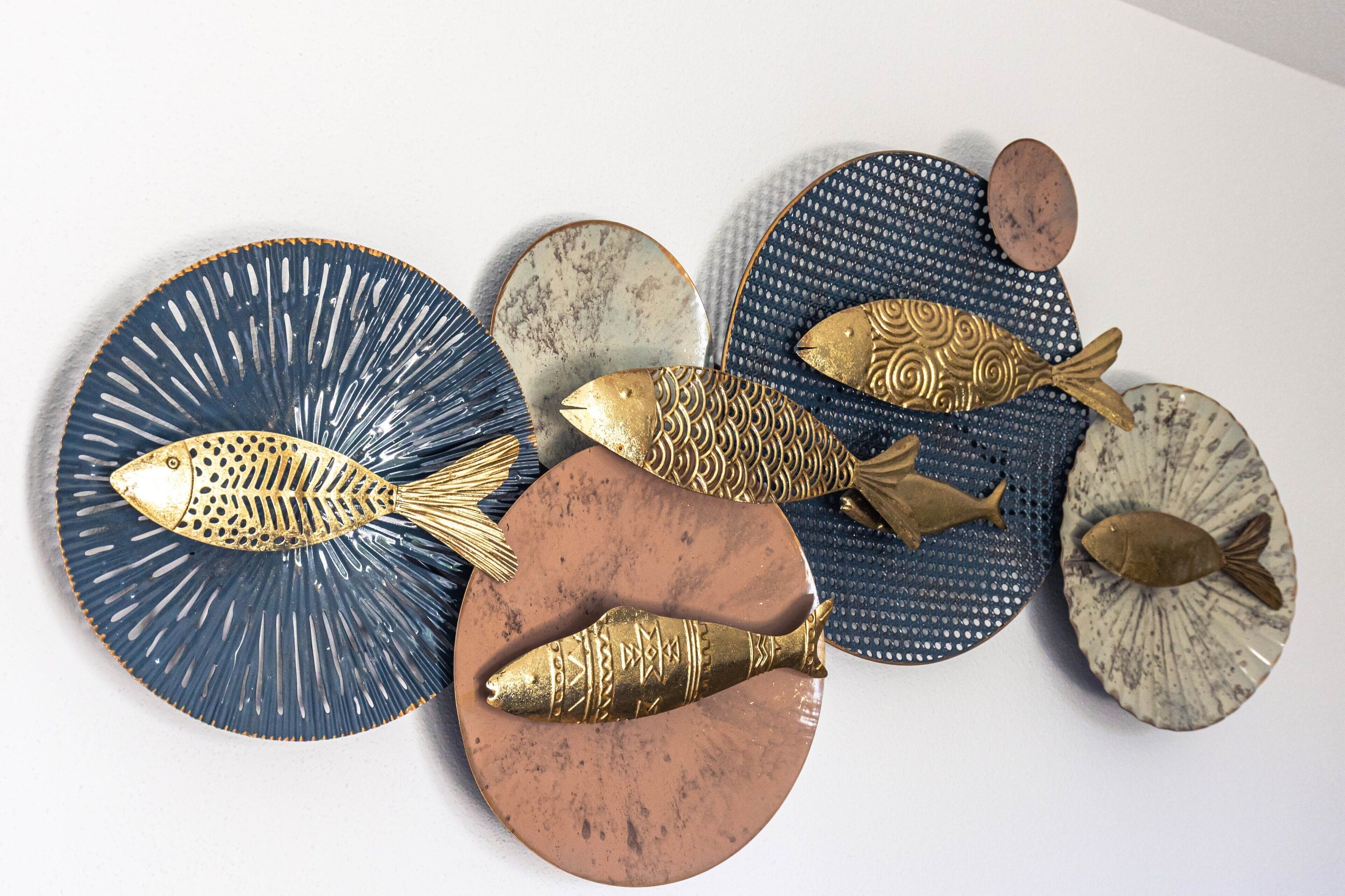 A collection of decorative fish-shaped objects on various textured surfaces.