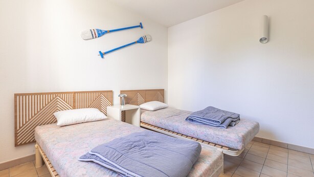 Ein Hotelzimmer mit zwei Betten, einem Nachttisch und einer Wandlampe.
