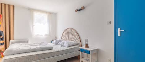 Une chambre à coucher avec un lit, une table de chevet, une lampe et une porte bleue.