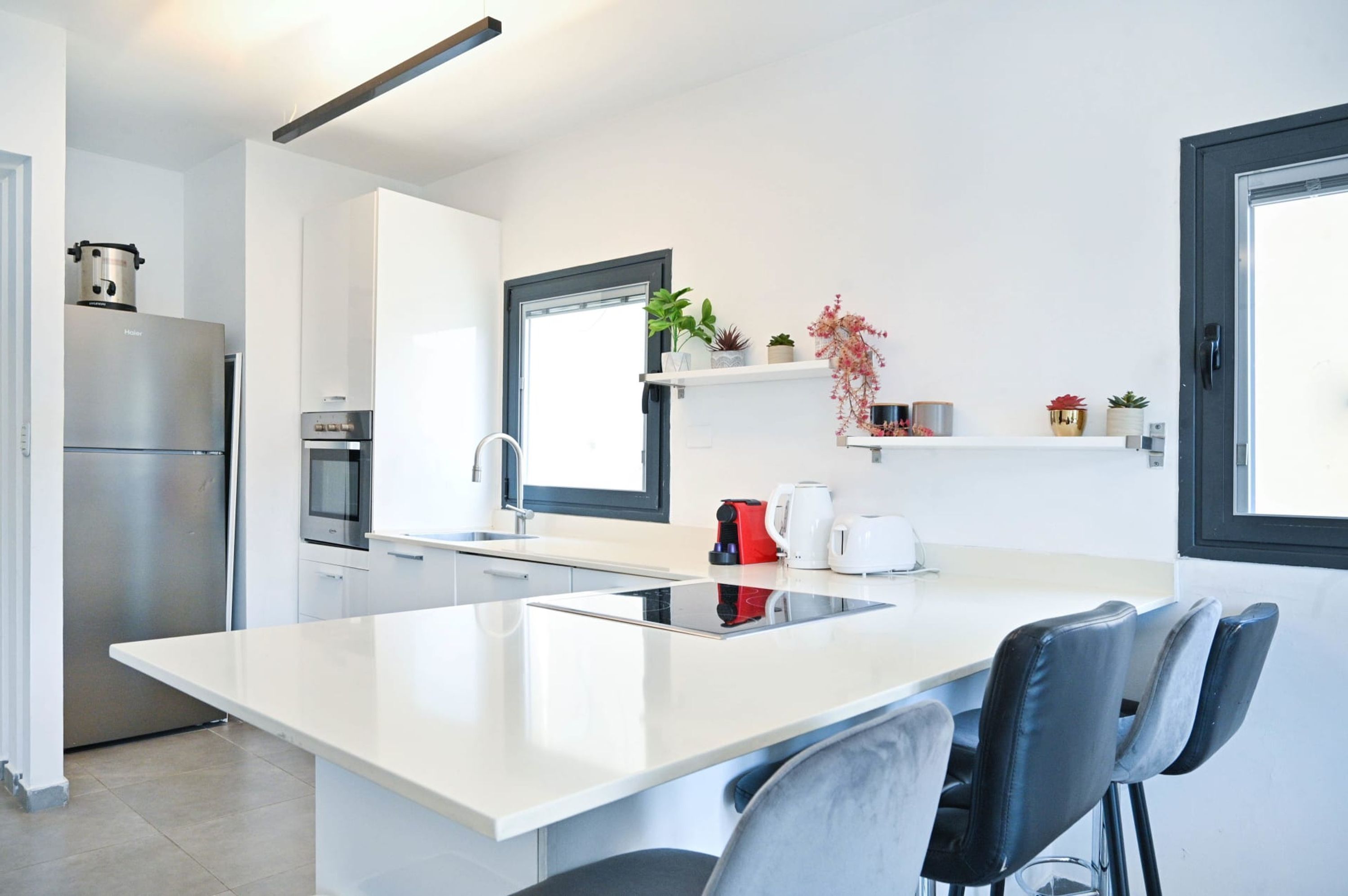 Una cocina moderna con una isla central, electrodomésticos de acero inoxidable y un diseño minimalista.