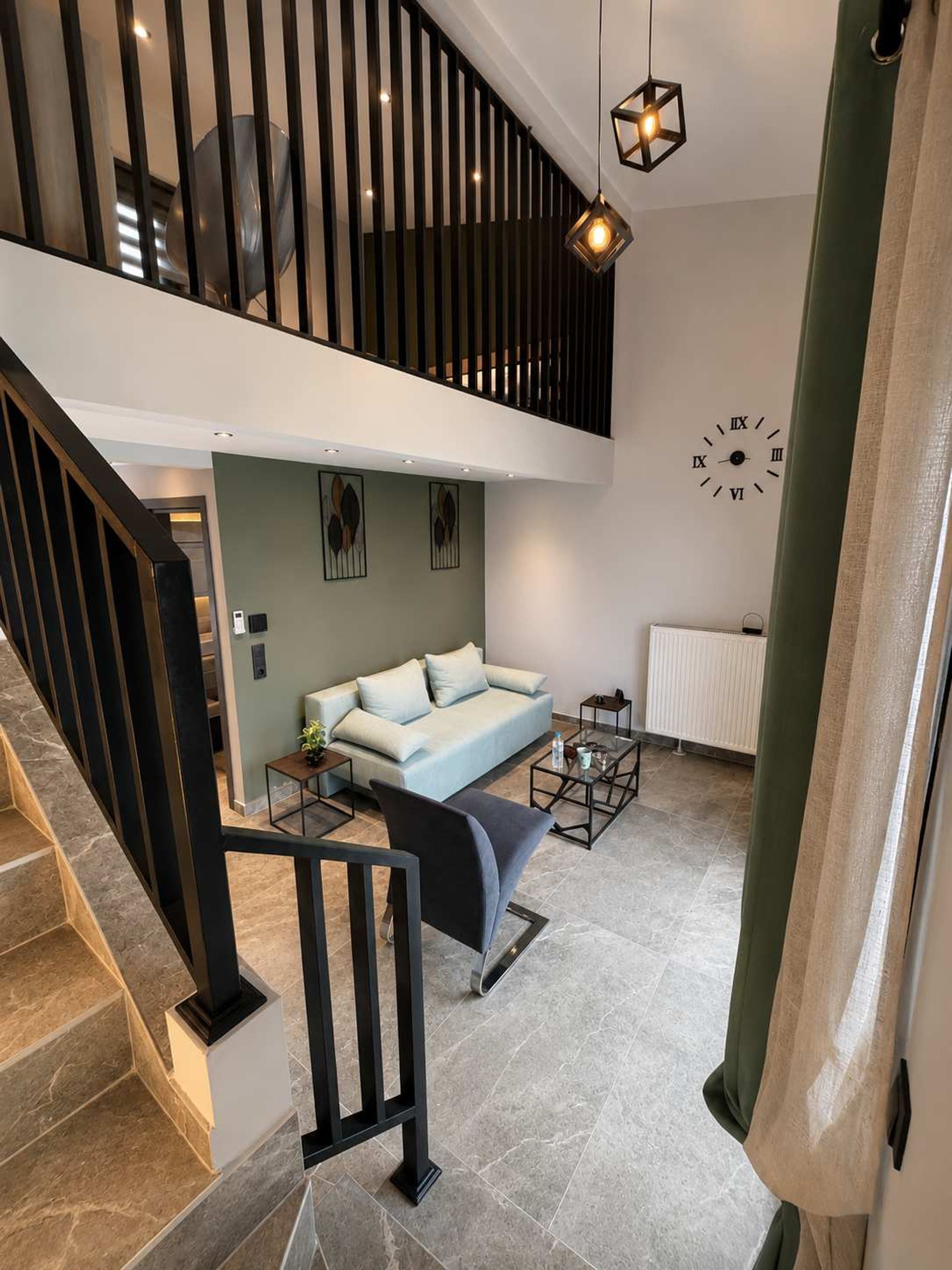 A modern interior with a staircase, a sofa, a coffee table, and a wall clock.