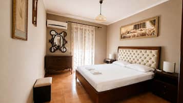 Um quarto com uma cama de madeira, uma cômoda, um espelho, um ar condicionado e um quadro na parede.