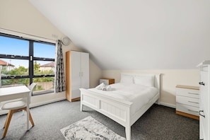 Une chambre à coucher avec un lit, un bureau et une armoire.