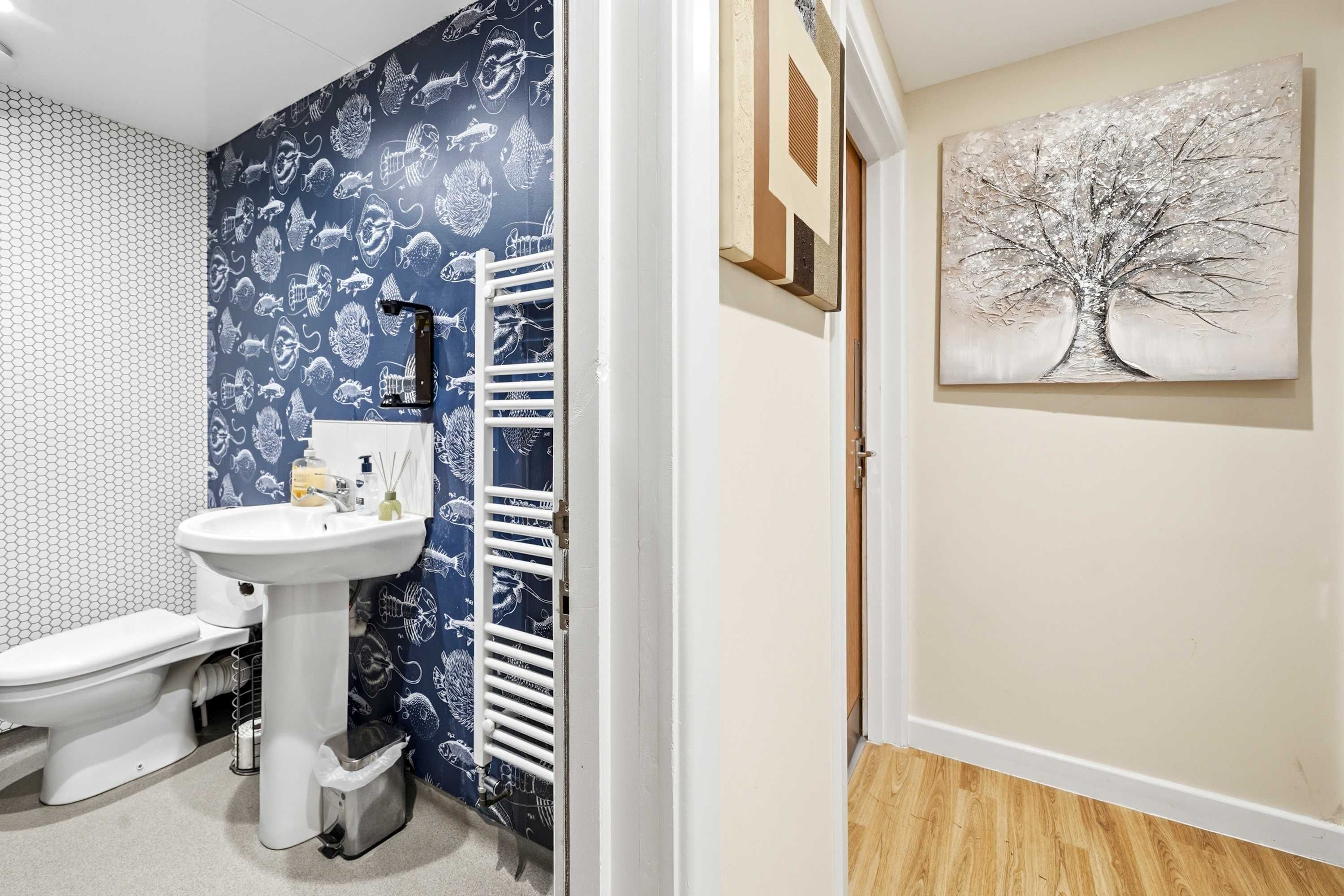 Een badkamer met een wit wastafel, toilet en een handdoekhouder.