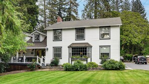 A two-story house with a porch, a covered front entrance, and a well-maintained lawn.