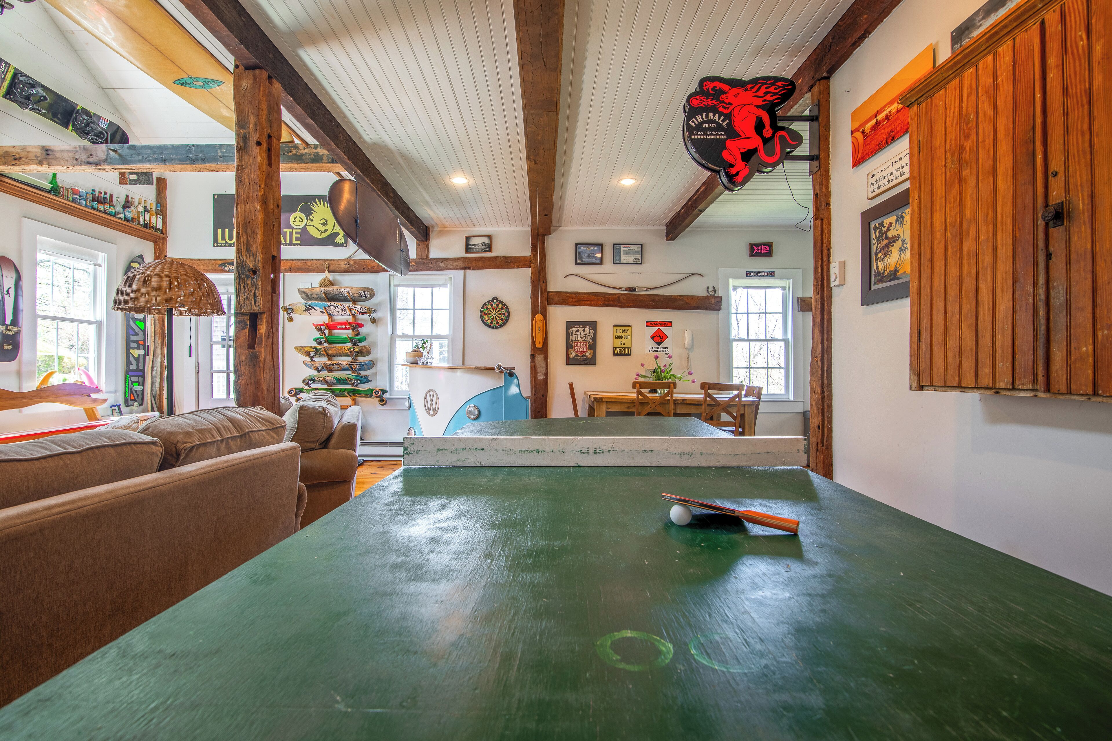 A room with a green table, a dartboard, and a wooden ceiling.