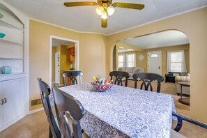 A dining area with a table set for four, a ceiling fan, and a view into another room. - 2 Blocks to Beach! Lake Huron Hideaway (Fort Gratiot)
