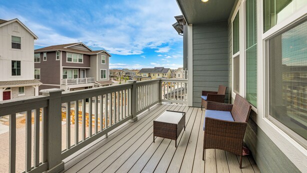A balcony with wicker furniture, a view of neighboring houses, and a clear sky. - Pets Welcome! Thornton Extended Stay w/ Balcony (Thornton)