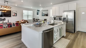 A modern kitchen with white cabinetry, a stainless steel refrigerator, and a built-in dishwasher. - Pets Welcome! Thornton Extended Stay w/ Balcony (Thornton)