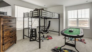 A bunk bed, a desk with a chair, a dresser, and a pool table in a room with large windows. - Pets Welcome! Thornton Extended Stay w/ Balcony (Thornton)