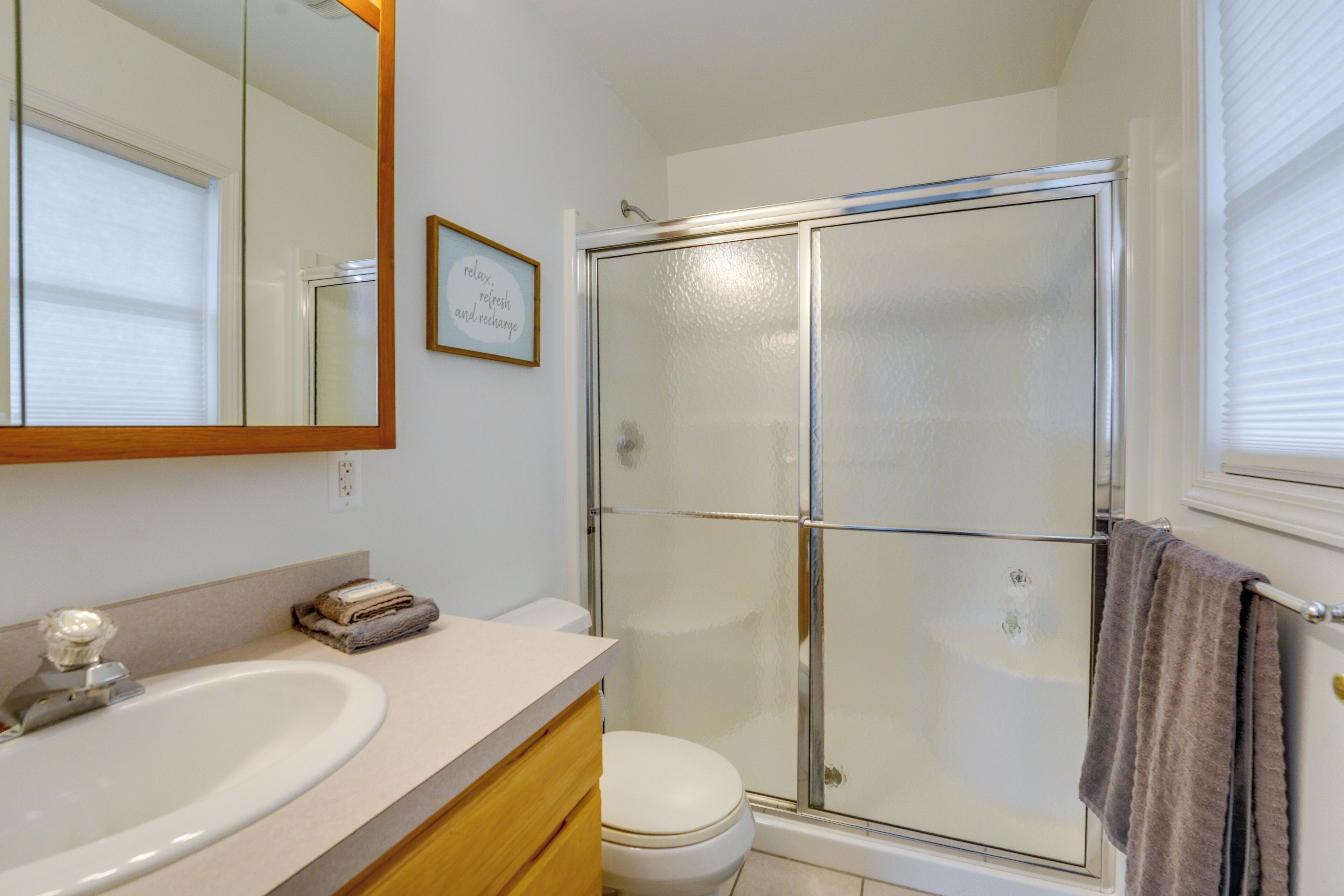 Une salle de bain avec une douche à parois de verre, un lavabo et des toilettes.