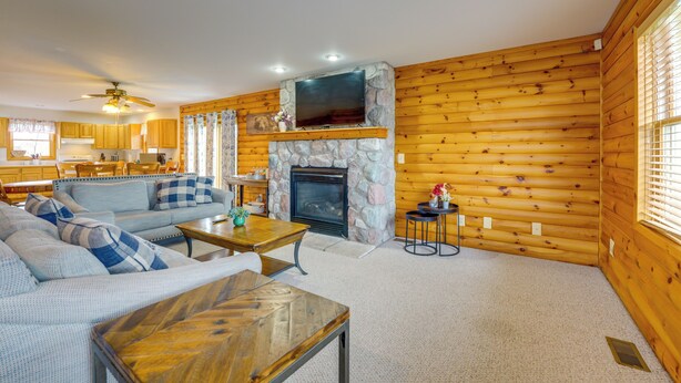 A log cabin interior with a living room, kitchen, and fireplace. - Fire Pit & Grill! Spacious Port Huron Home By Dtwn (Port Huron)