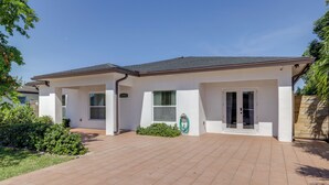 Een modern huis met twee verdiepingen, een verharde oprit, een overdekte patio en een zichtbare garage.
