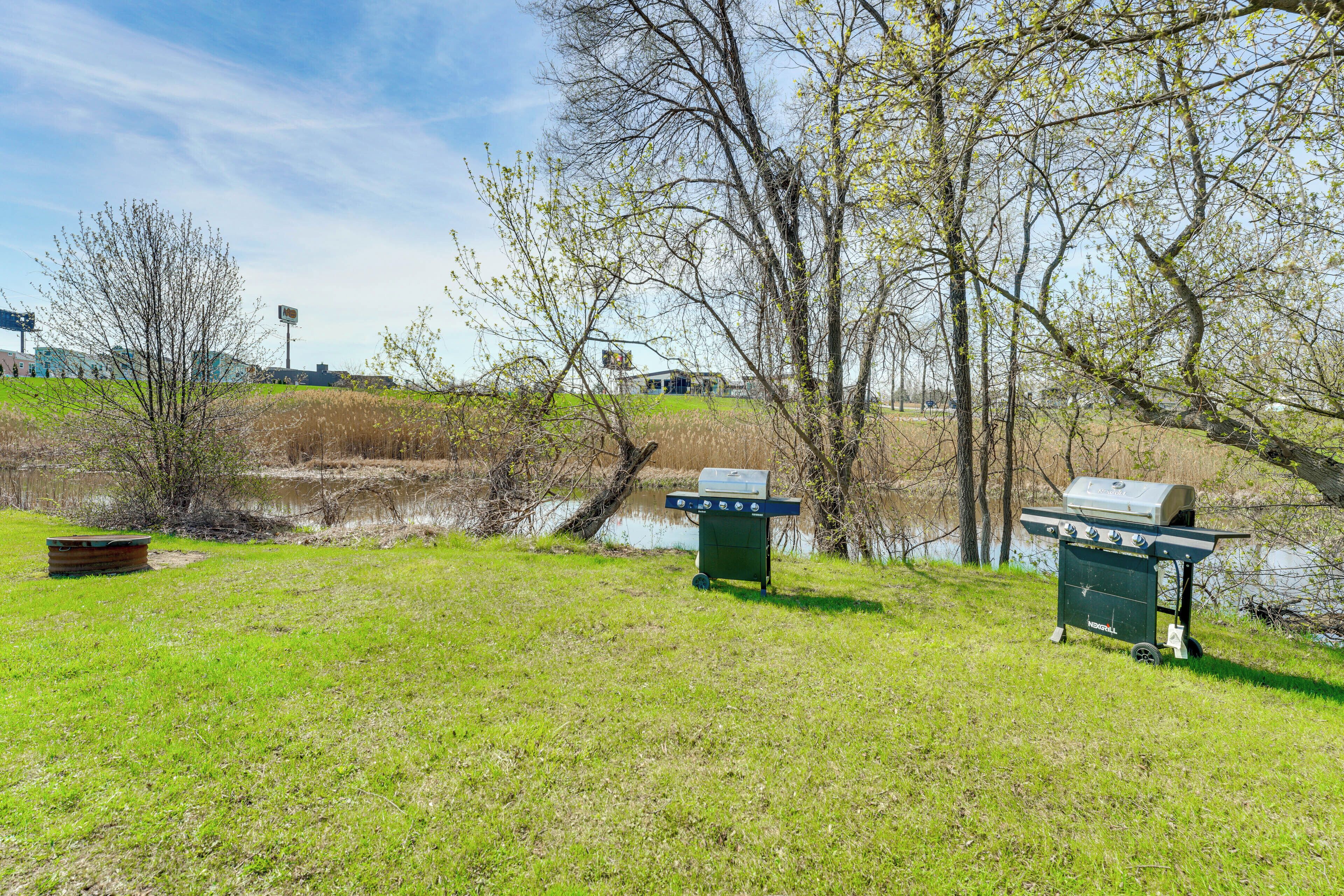 A grassy area with a grill cart and a boat.