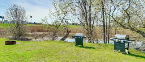 A grassy area with a grill cart and a boat.