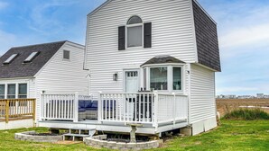 A two-story house with a balcony, a small porch, and a view of the surrounding landscape. - Coastal Hampton Condo: Walk to North Beach! (Hampton)