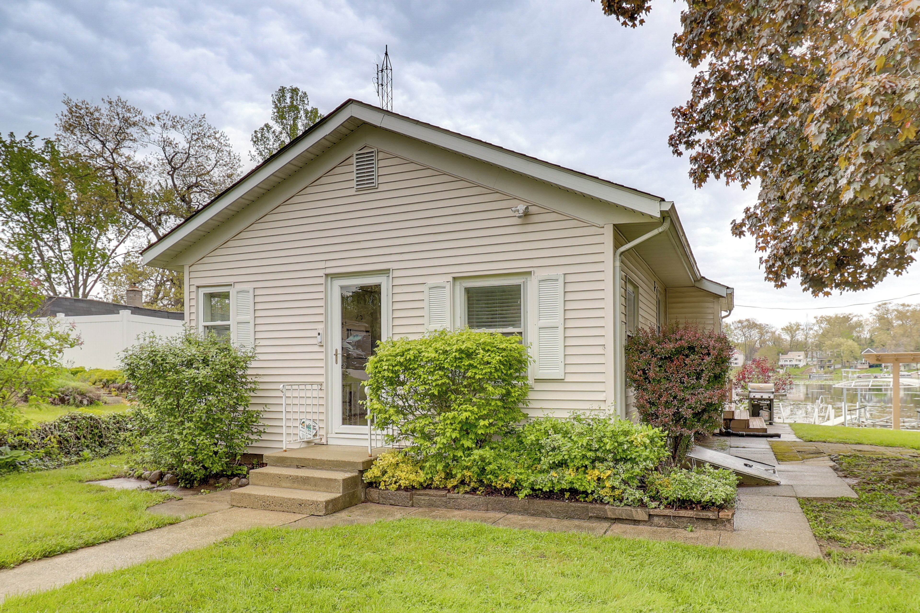 A single-story house with a front porch, a small garden, and a clear sky.