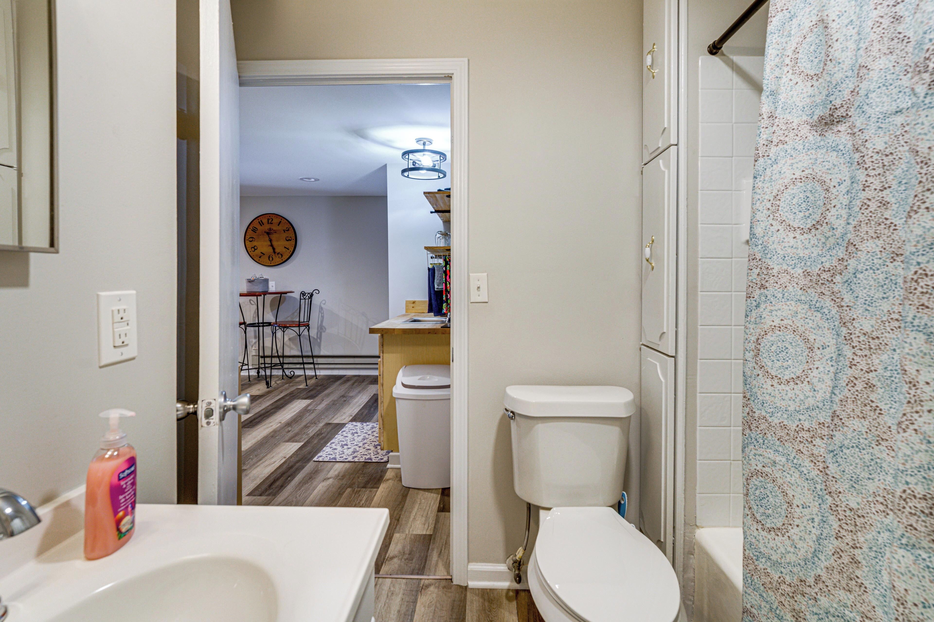 A bathroom with a toilet, sink, and shower curtain.