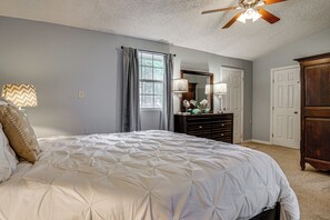 A bedroom with a large bed, a dresser, a mirror, a ceiling fan, and a window. - 5 Mi to Will Rogers Center! Private Oasis w/ Grill (Fort Worth)