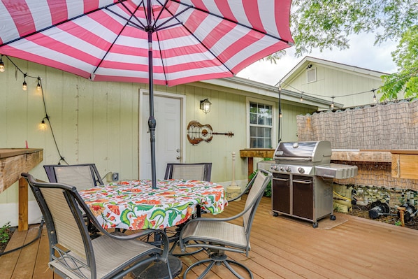 A patio with a table, chairs, a grill, and an umbrella. - 5 Mi to Will Rogers Center! Private Oasis w/ Grill (Fort Worth)