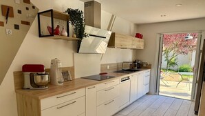 Una cocina moderna con horno integrado, cafetera y pileta.