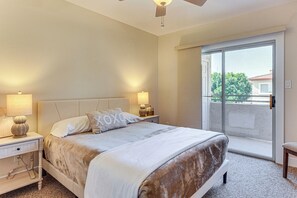 A bedroom with a bed, nightstands, a ceiling fan, and a sliding glass door to a balcony. - Community Perks! Modern PHX Condo: Extended Stay! (Phoenix)