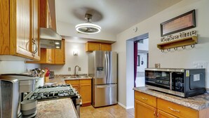 A kitchen with wooden cabinets, stainless steel appliances, a gas stove, and a microwave. - Outdoor Sanctuary + Gym! Retreat 4 Mi to Reid Park (Tucson)