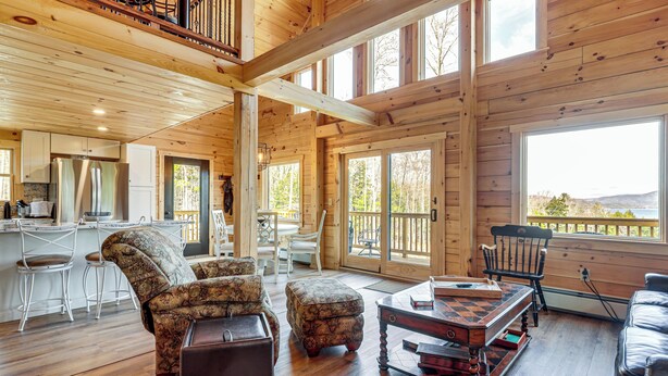 A spacious wooden cabin interior with a kitchen, dining area, and seating. - Newfound Lake Getaway: Cabin w/ Deck, Fire Pit (Bristol)