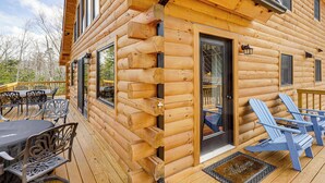 A log cabin with a deck, outdoor seating, and a door leading to the interior. - Newfound Lake Getaway: Cabin w/ Deck, Fire Pit (Bristol)