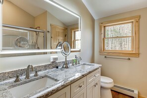 A bathroom with a double sink, a toilet, a large mirror, and a window. - Newfound Lake Getaway: Cabin w/ Deck, Fire Pit (Bristol)