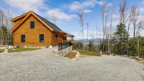 A wooden cabin with a porch, a gravel driveway, and a forested backdrop. - Newfound Lake Getaway: Cabin w/ Deck, Fire Pit (Bristol)