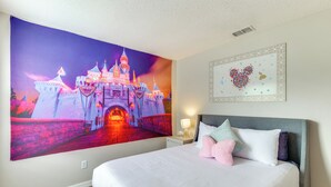 Una camera da letto con un grande affresco raffigurante un castello, una decorazione a forma di cuore e un letto ben rifatto con cuscini.