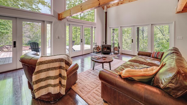 A spacious living room with a large leather sofa, a wooden coffee table, and a fireplace.