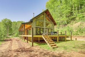 A cabin with a wooden deck, large windows, and a staircase leading to the entrance. - 'the Appalachian Hideaway' w/ Hiking Trails & Deck (Walton)