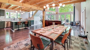 A spacious kitchen with a central island, a dining area with a wooden table and chairs, and a cozy seating area with a fireplace.