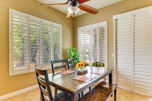 A dining area with a table, chairs, a ceiling fan, and windows with shutters. - Pool, Hot Tub, Toys! Family Home, 4 Mi to Luke AFB (Litchfield Park)