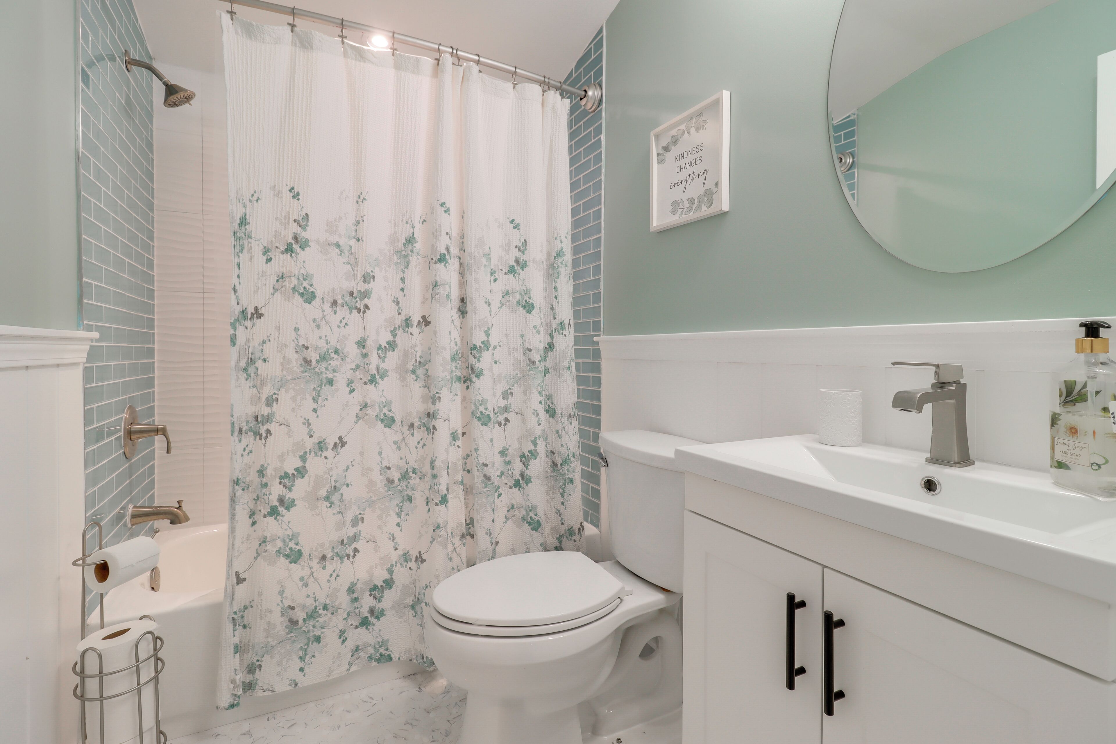A bathroom with a toilet, sink, and shower curtain.