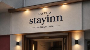 A boutique hotel sign with 'DATCA stayinn' and 'boutique hotel' text.
