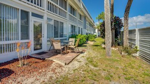 A building with a patio area, outdoor seating, and palm trees. - 2 Mi to Sand! Port Charlotte Condo w/ Pool Access (Punta Gorda)