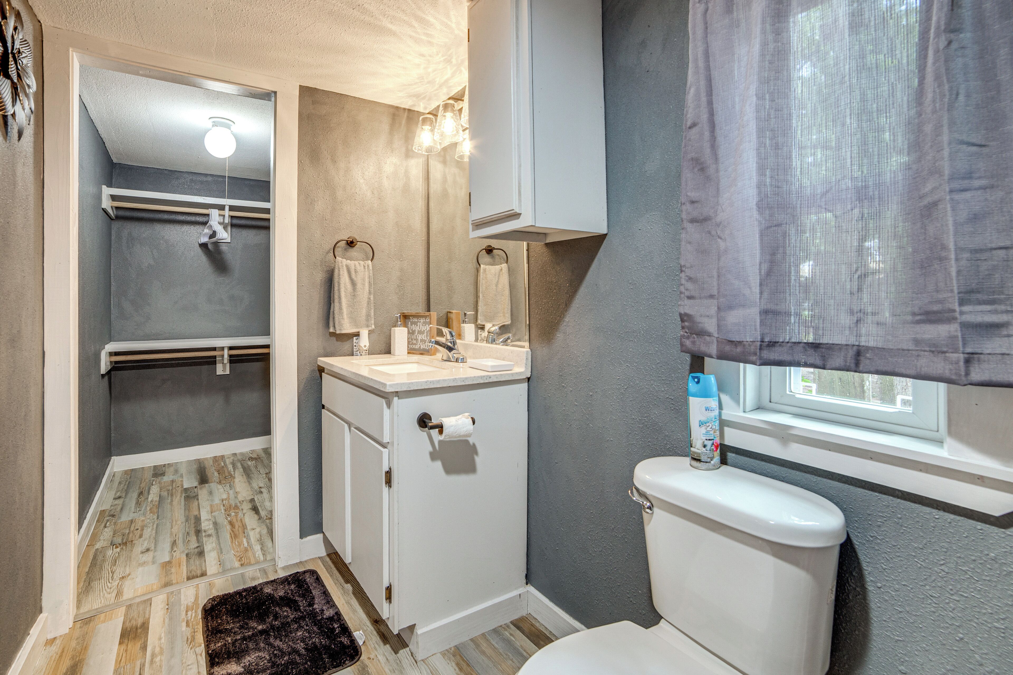 A bathroom with a shower, toilet, sink, and vanity.