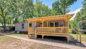 A wooden decked structure with a porch, a small staircase, and a window. - Lake Tawakoni Basecamp: Covered Patio + Fire Pit! (Wills Point)
