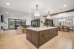 A spacious kitchen with a large island, wooden cabinets, and pendant lighting. - Gorgeous Family Retreat Access to Forest House (Sunriver)