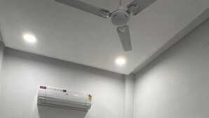 Una habitación de hotel con cama, ventilador de techo y aire acondicionado.