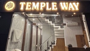 Un edificio con un cartel que dice 'TEMPLE WAY' y un logotipo arriba.