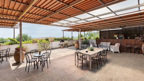 An outdoor patio with tables and chairs, a grill area, and a view of the surrounding landscape. - Room 'Camera Rosa' with Mountain View, Wi-Fi and Air Conditioning (Pontecagnano Faiano)