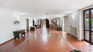 A spacious hallway with a tiled floor, a bench, and a radiator. - Room 'Camera Rosa' with Mountain View, Wi-Fi and Air Conditioning (Pontecagnano Faiano)